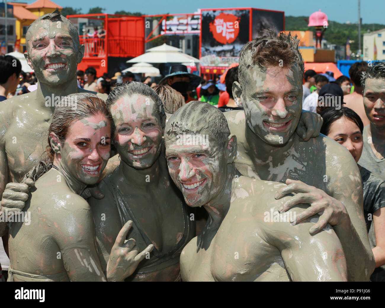 Festival goers covered in mud